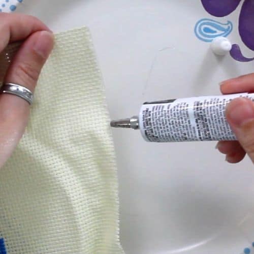 Applying fabric glue to the edge of aid cloth to prevent fraying