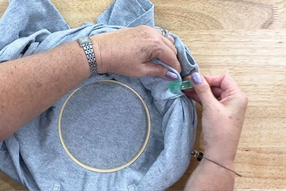 Showing Bridget clipping the back of a t-shirt to keep it out of the way while stitching.