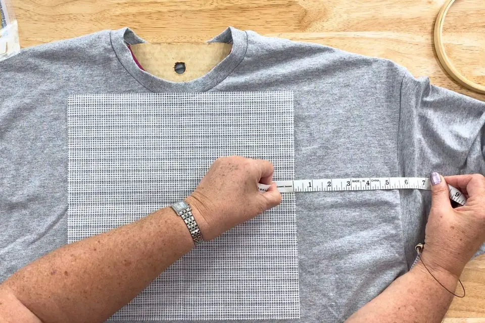 Measuring the placement of the waste canvas on a t-shirt.