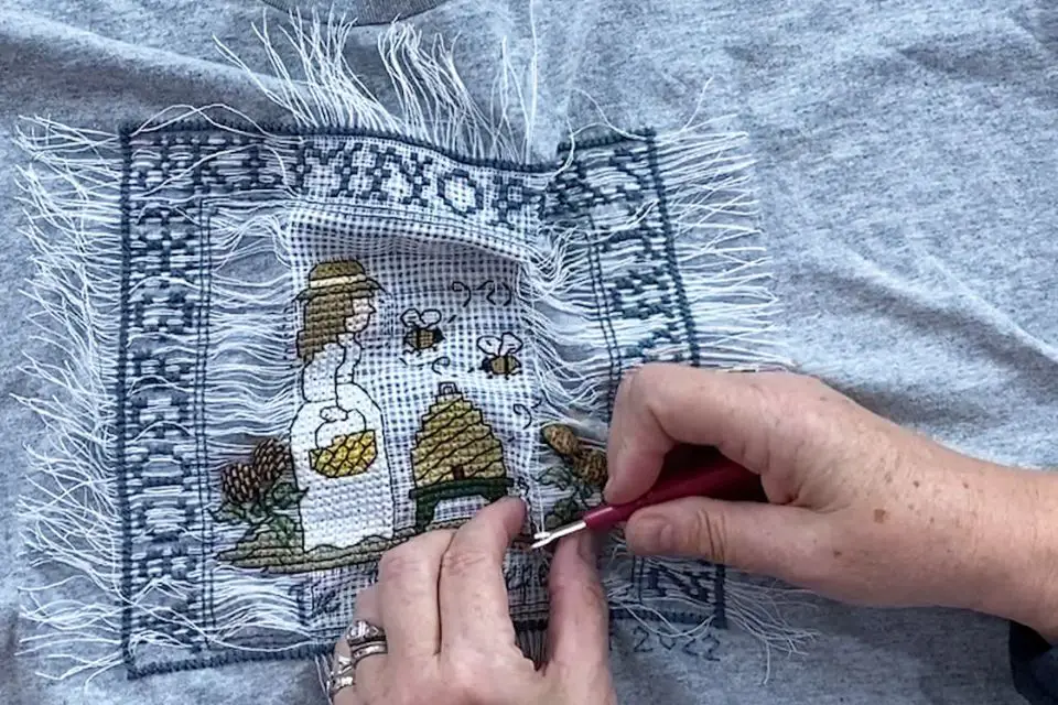 Use a seam ripper to gently work out a difficult waste canvas fiber.